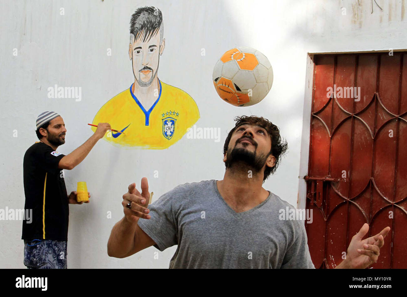 An artist making portrait of Brazil Football player Neymar Jr. on a wall ahead of the start of FIFA World Cup 2018, in Karachi on Monday, June 04, 2018. Stock Photo