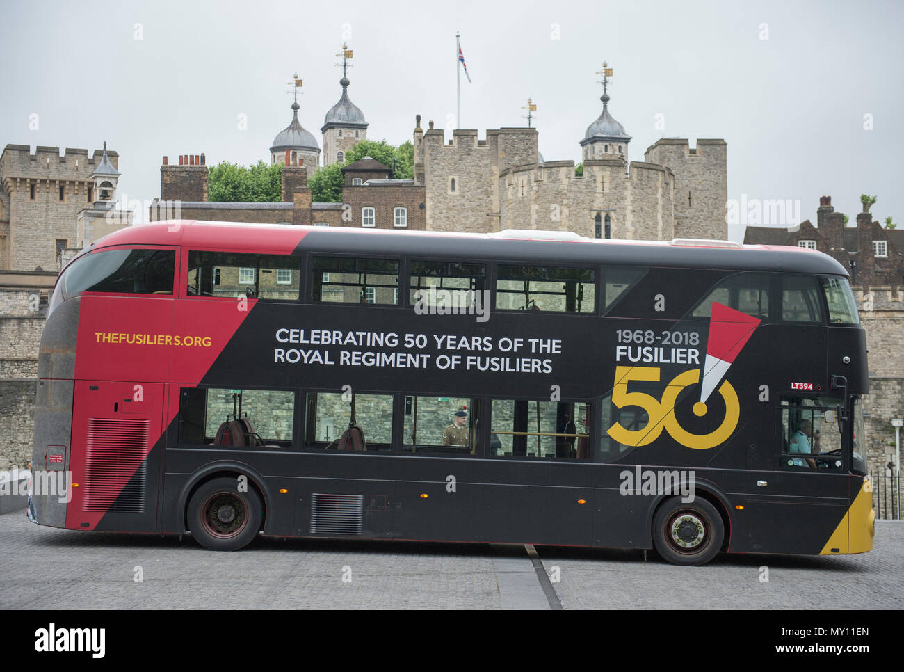 Tower of London, UK. 5 June, 2018. To mark the special occasion of the Royal Regiment of Fusiliers 50th anniversary a new double decker Routemaster bus has been wrapped in the Regimental colours of rose and primrose on a striking black background and features the Fusilier 50 logo. The initiative is a joint partnership between the Royal Regiment of Fusiliers, Go-Ahead London, Exterion Media and Historic Royal Palaces, an independent charity who look after The Tower of London. Credit: Malcolm Park editorial/Alamy Live News Stock Photo