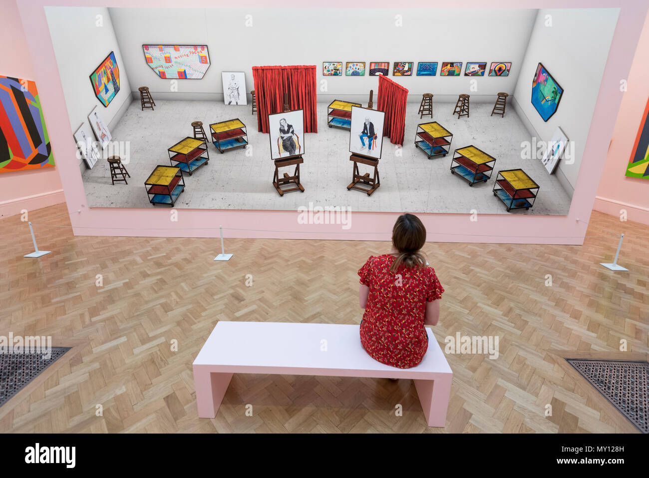 London, UK.  5 June 2018.  A staff member views 'Seven Trollies, Six and a Half Stools, Six Portraits, Eleven Paintings and Two Curtains' by David Hockney RA at the preview of the 250th Summer Exhibition at the Royal Academy of Arts in Piccadilly, which has been co-ordinated by Grayson Perry RA this year.  Running concurrently, is The Great Spectacle, featuring highlights from the past 250 years.  Both shows run 12 June to 19 August 2018. Credit: Stephen Chung / Alamy Live News Stock Photo