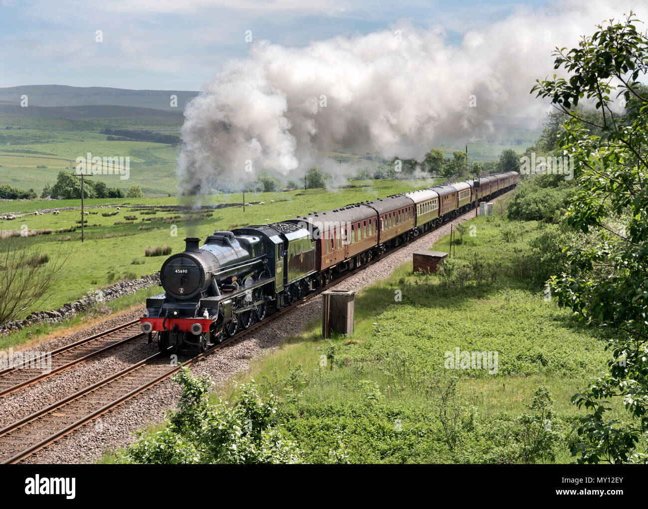 Ribblehead, UK. 5th June, 2018. The Dalesman steam special passes Saltlake Cottages on the uphill gradient near Ribblehead on the Settle-Carlisle railway line, 5th June 2018. The train is a regular feature on the line during Summer months. The locomotive here is a Stanier Jubilee Class engine named 'Leander'. Credit: John Bentley/Alamy Live News Stock Photo