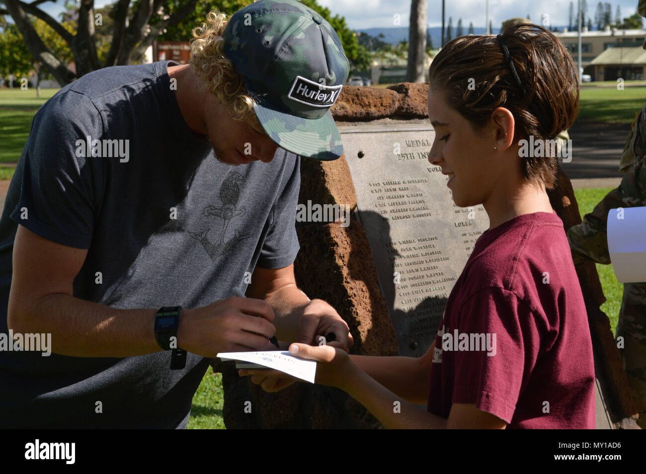 Pro surfer John "John" Alexander Florence signs his autograph for a young  fan at Schofield Barracks, Hawaii, on Dec. 13, 2016. Florence is the 2016  World Surf League Men's Champion and participating