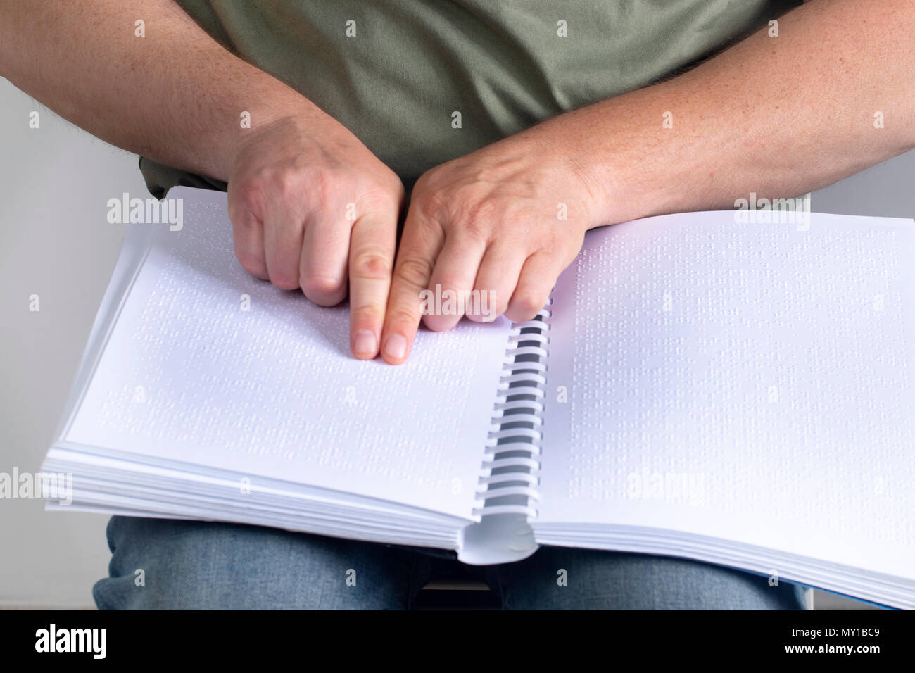 Blind man was reading a book written on Braille. Stock Photo