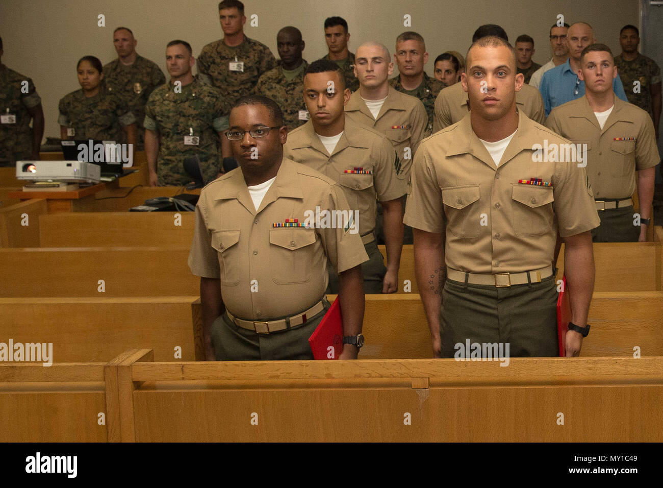 CAMP HANSEN, OKINAWA, Japan - Lance Cpl. Cory Watkins, right, and Pfc. Keanté Anderson, left, stand at the position of attention as Anchor’s Away plays May 30 on Camp Hansen, Okinawa, Japan. The Correctional Custody Unit 2.0 (CCU) graduation was held to commemorate the return of Marines to their units. Lance Cpl. Cory Watkins returned 3rd Battalion, 3rd Marine Regiment and Pfc. Keanté Anderson returned to Marine Air Control Squadron 4, Marine Tactical Air Command Squadron 18. Stock Photo