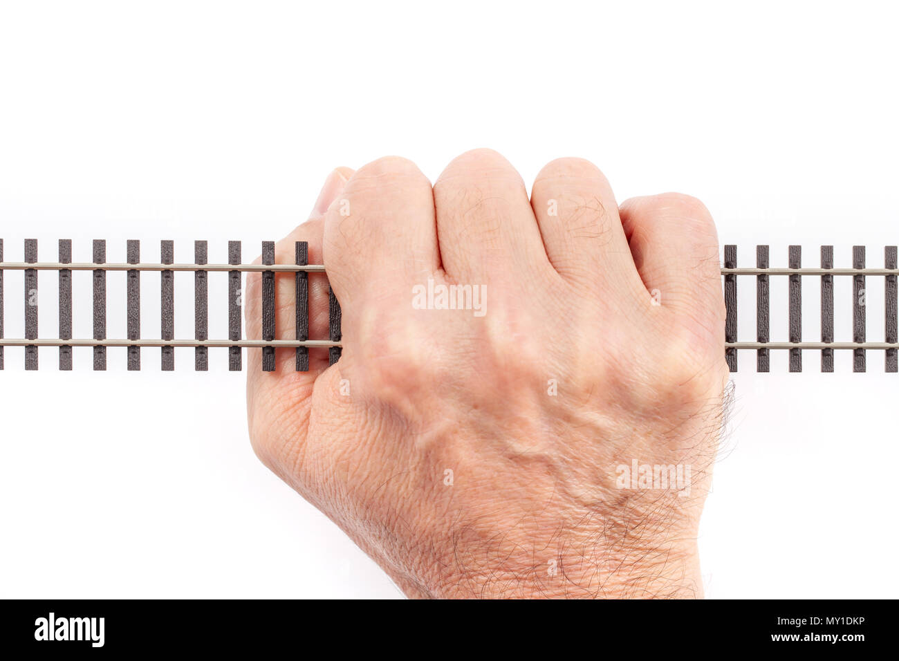 Single rail toy catched up in a human hand isolated on white. Conceptual image. Stock Photo