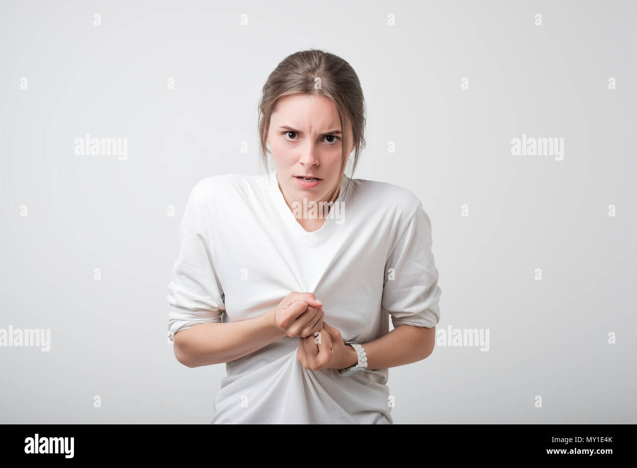 Picture of enraged dissatisfied young caucasian teenager grimacing and making angry gesture while feeling furious Stock Photo