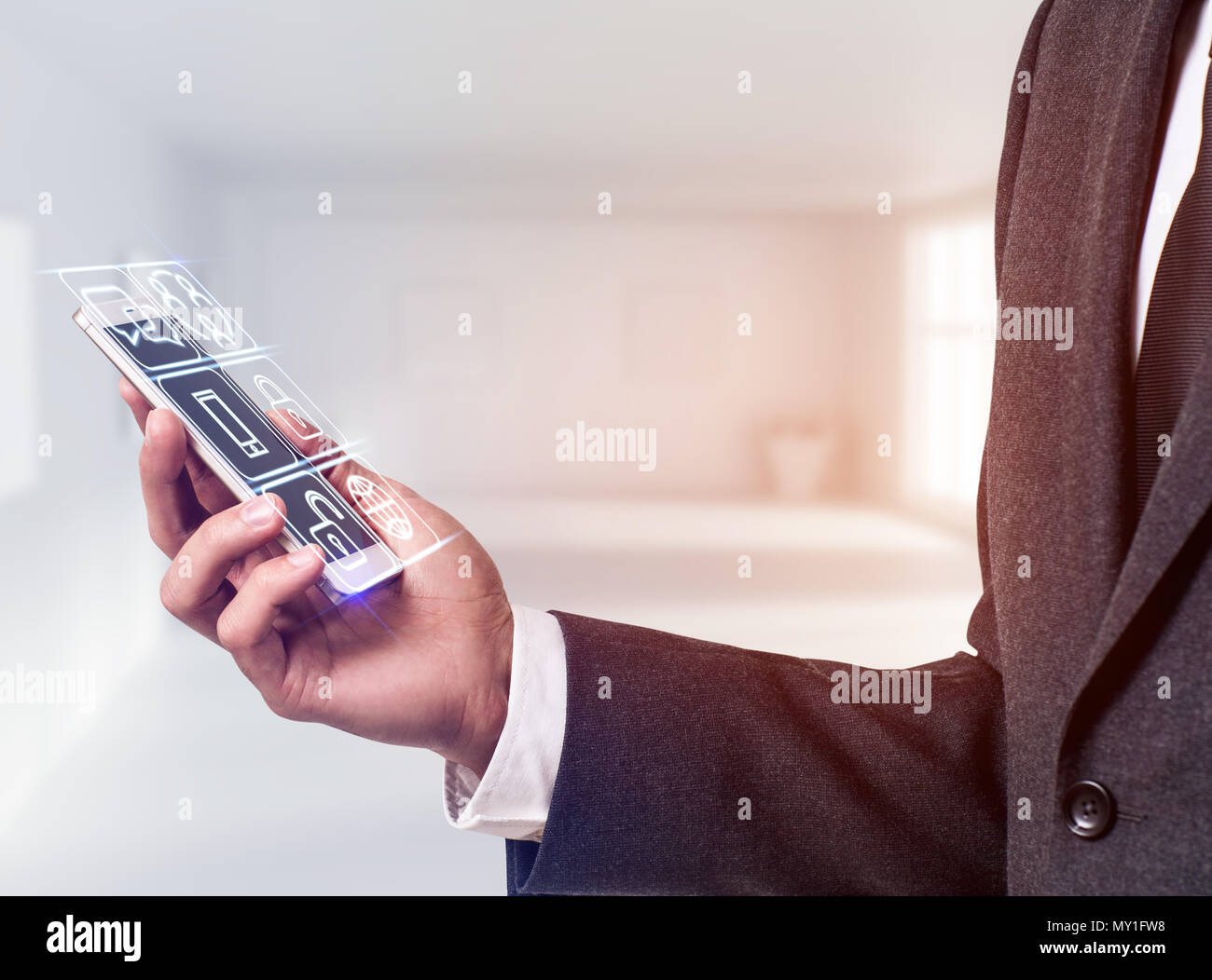 Businessman holding smart phone with media icons. Stock Photo