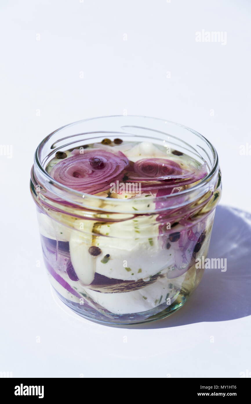 Marinated pickled cheese in oil with onions in glass jar Stock Photo