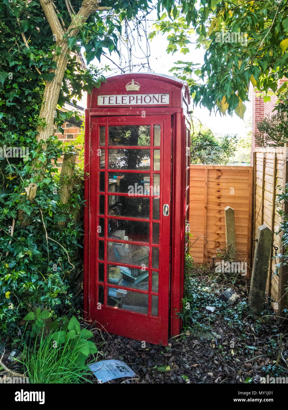 An old red telephone box used as a book swap location in a Wiltshire village. Stock Photo