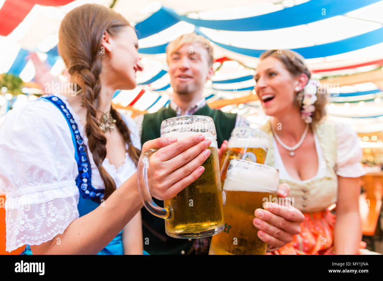 Friends with beer glasses at Bavarian beer tent Stock Photo
