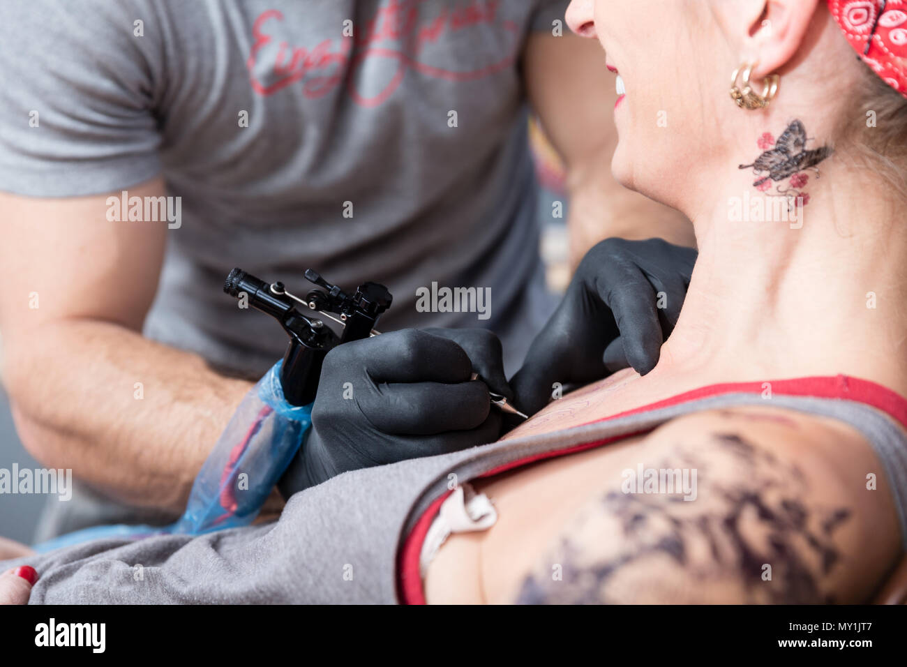 Skilled artist making the contour of a new tattoo on the skin of a client Stock Photo
