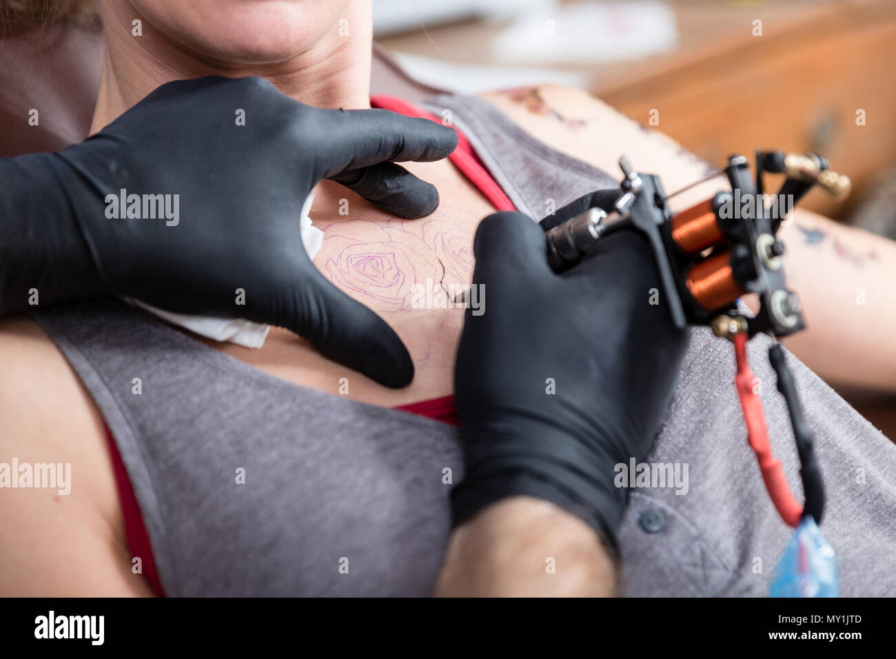 Close-up of the hands of a skilled artist making the contour of a tattoo Stock Photo