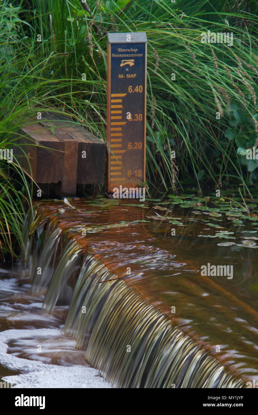 Water management: a small weir and a level meter in a Dutch river Stock Photo