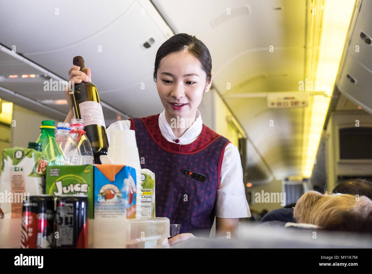 Interior,inside,Air China,flight,airline,stewardess,flight,cabin,crew,serving,service,drinks,food,on,flight,from,Beijing,Asia,Asian,to,London,Europe. Stock Photo