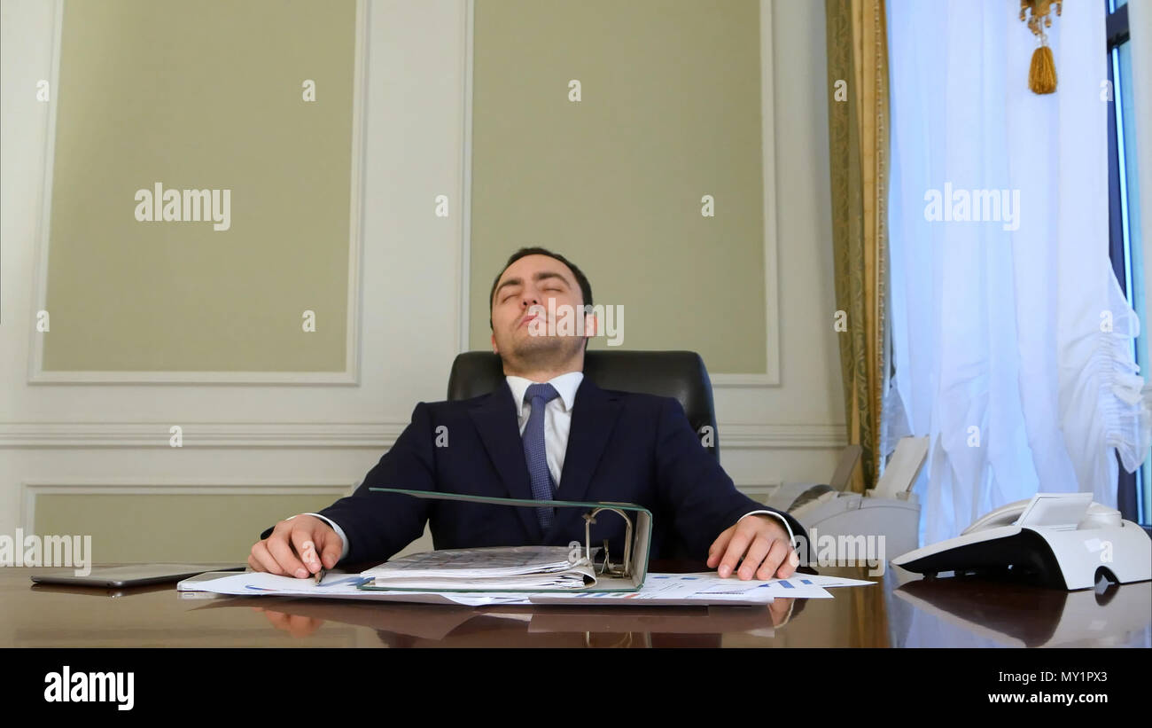 Overworked Businessman Falling Asleep In Office Stock Photo