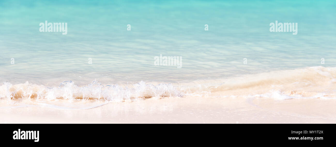 Waves on white sand and turquoise water; panoramic summer background Stock Photo