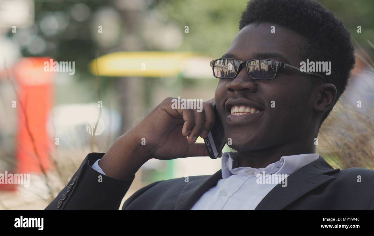 Handsome african american man laughs and talks on his cell phone Stock Photo