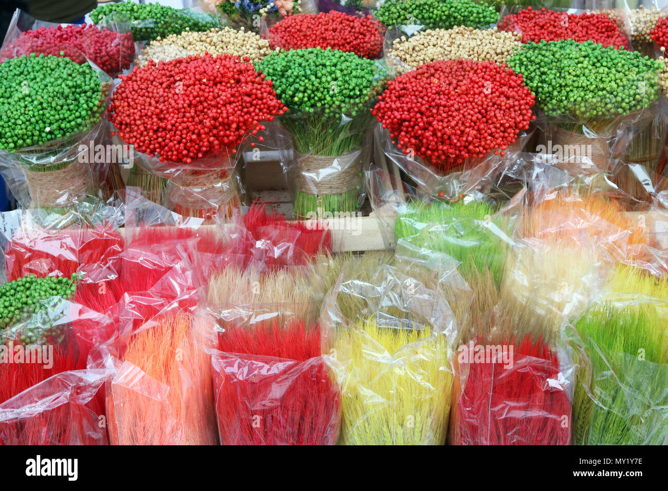 Multicolored paited  branches and ears are sold on the street during the spring traditional fair. CLoudy day outdoor shot Stock Photo