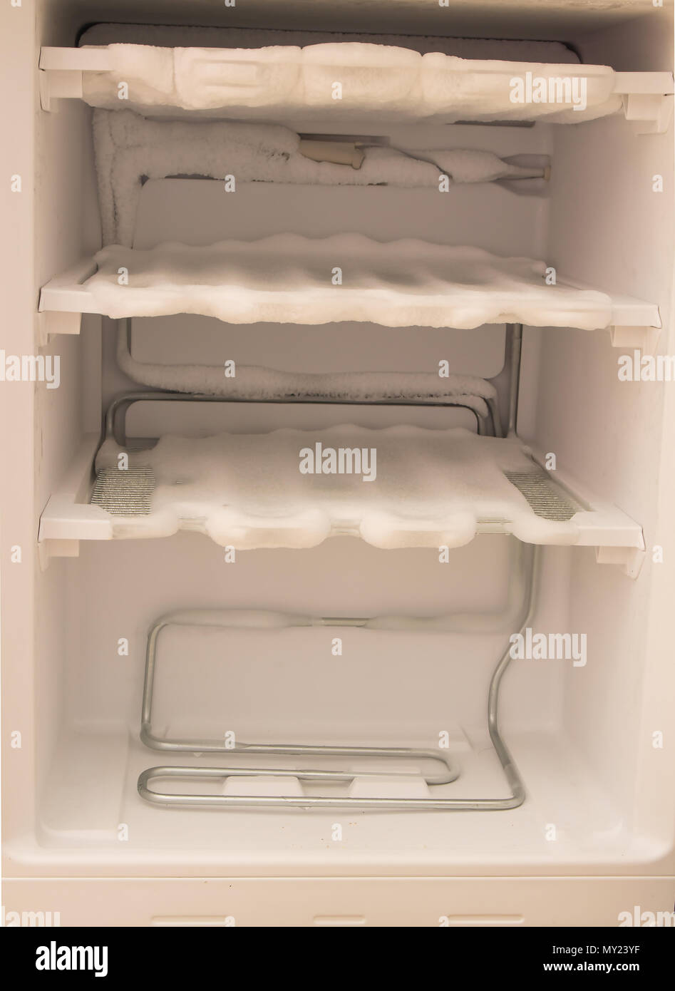empty freezer of a refrigerator , Ice buildup on the inside of a freezer walls background. Stock Photo