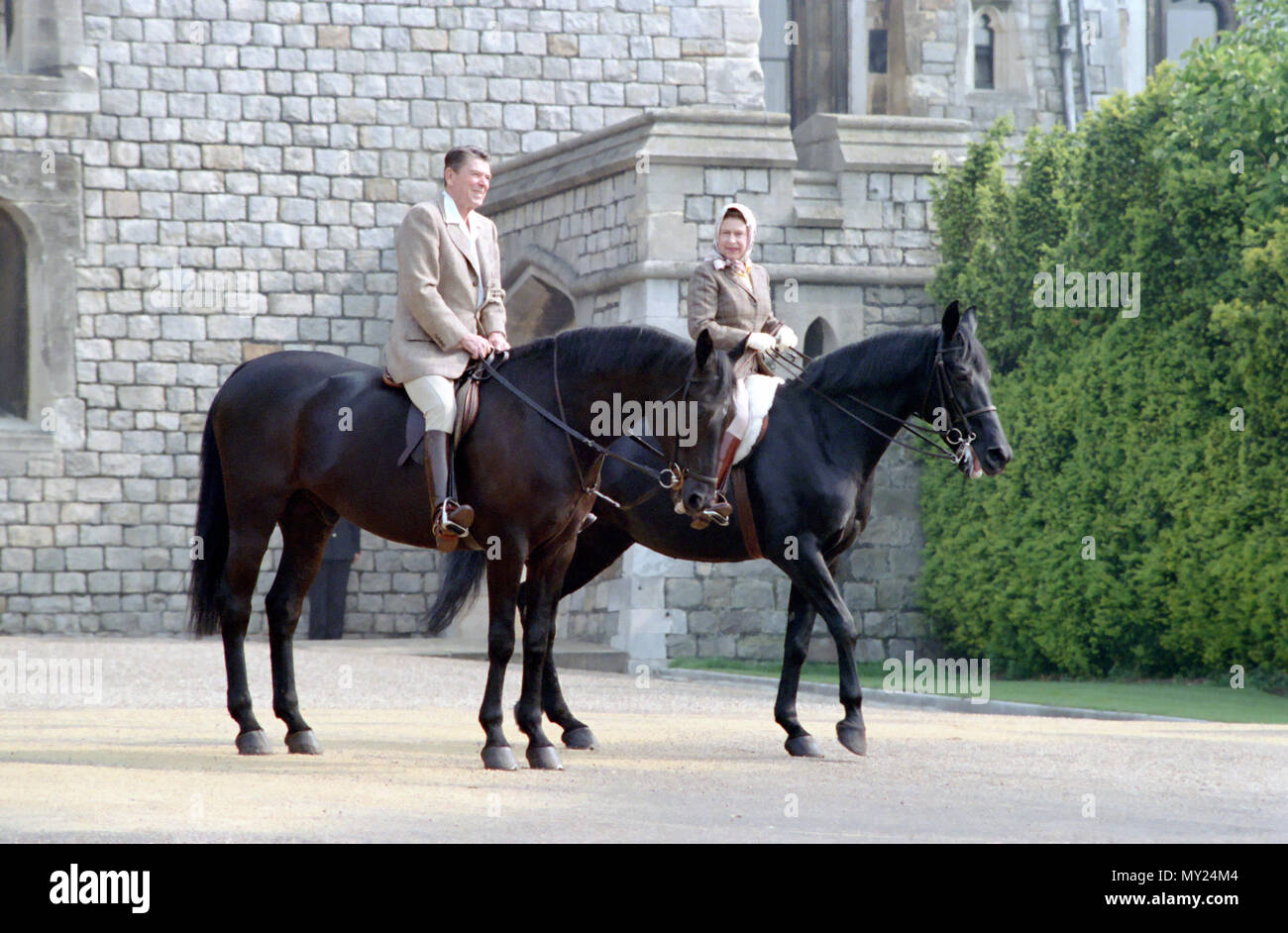 6/8/1982 President Reagan and Queen Elizabeth II horseback riding at Windsor Castle in England Stock Photo