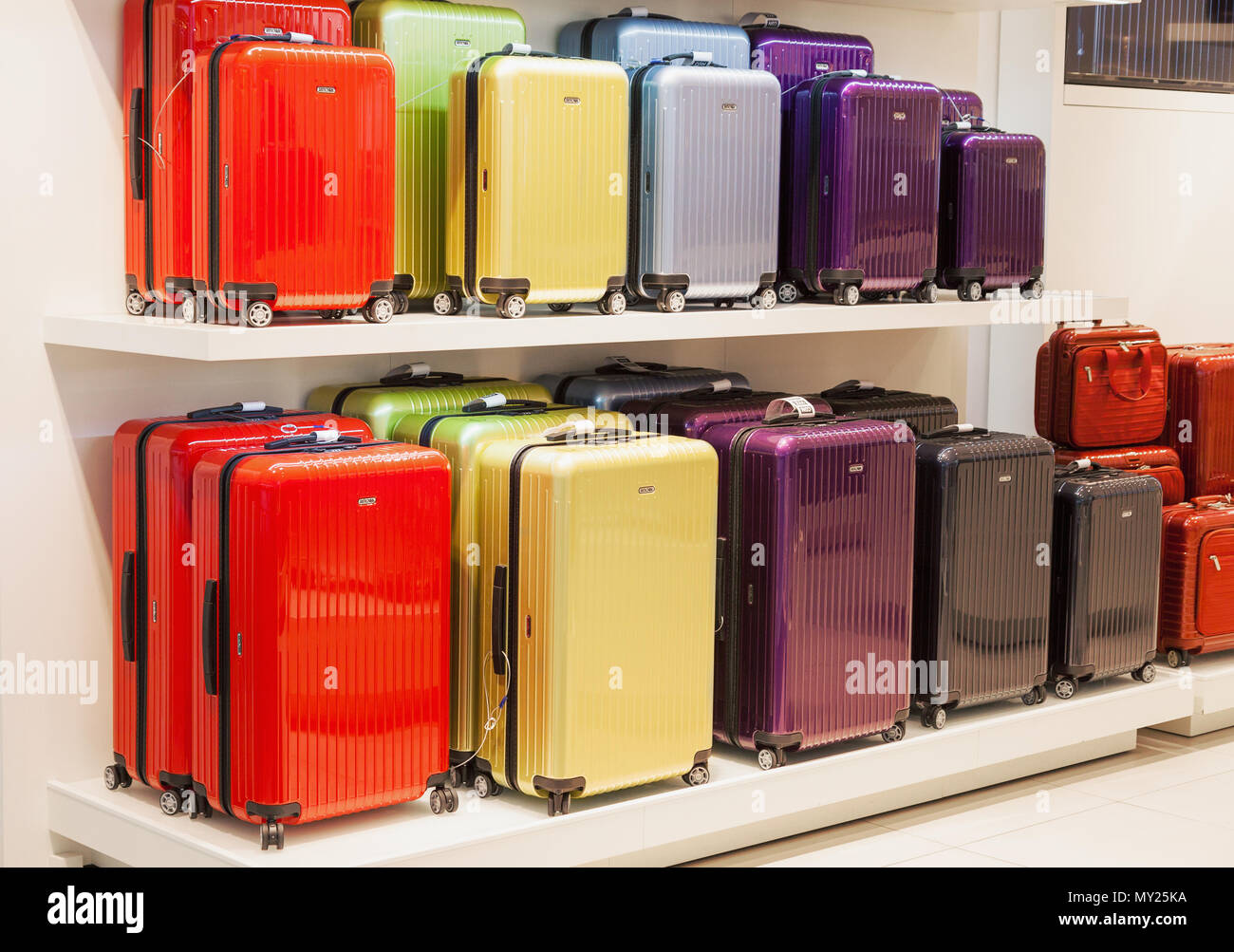 Modern style colorful metallic luggage bags of different sizes stacked on sale in shopping mall in Vilnius, Lithuania Stock Photo