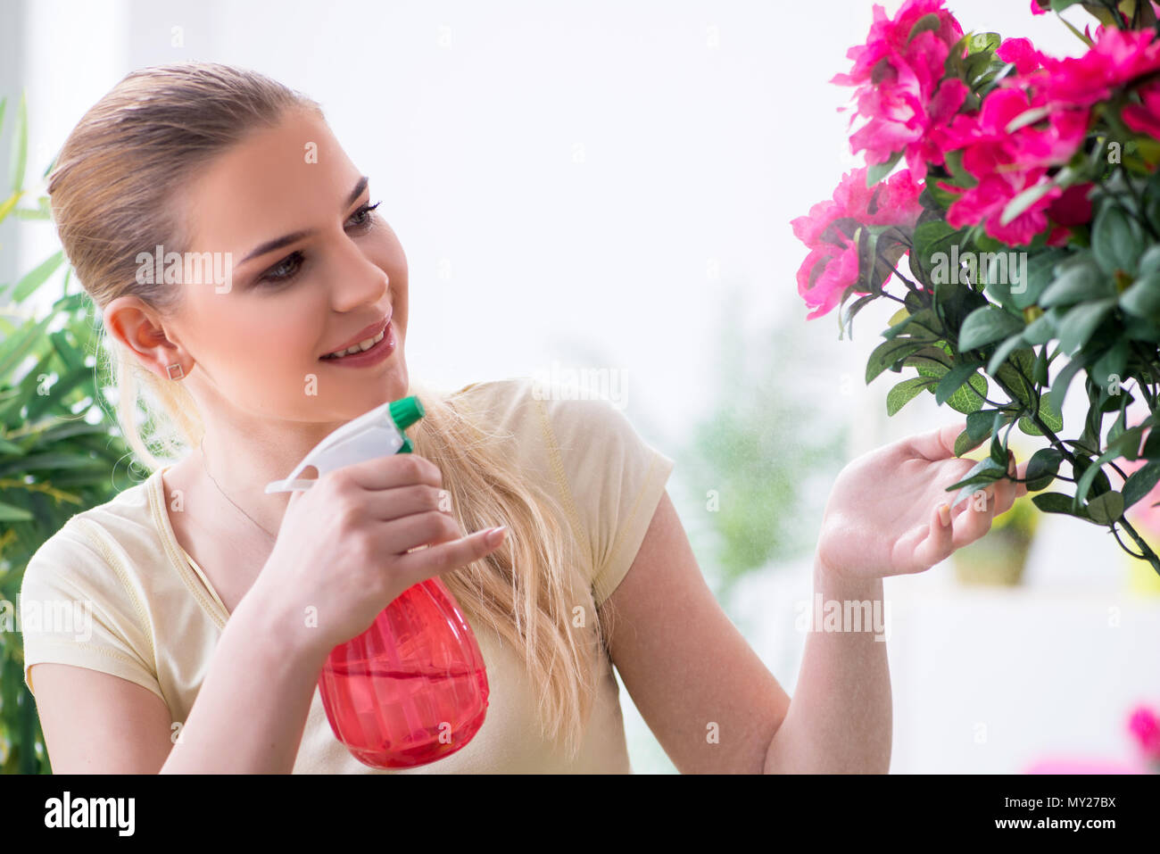 Young woman watering plants in her garden Stock Photo - Alamy