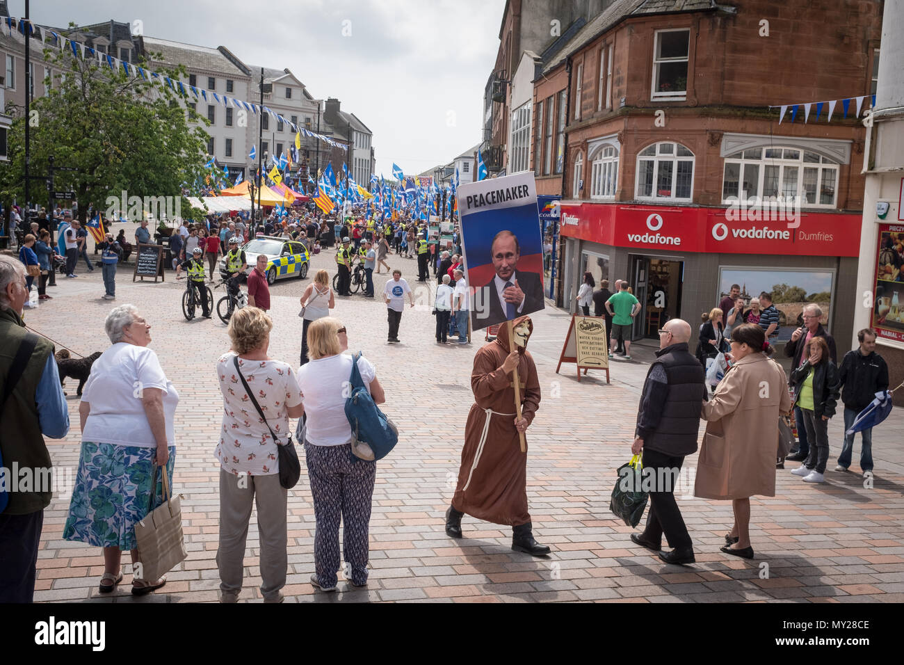 Dumfries town centre, Scotland, June 2nd 2018, a protester with a placard showing Vladimir Putin, wanders through the crowd before a march. Stock Photo