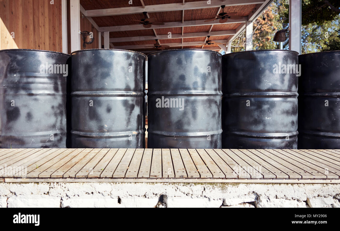 Black metal oil barrels in an outdoor storage space. Stock Photo