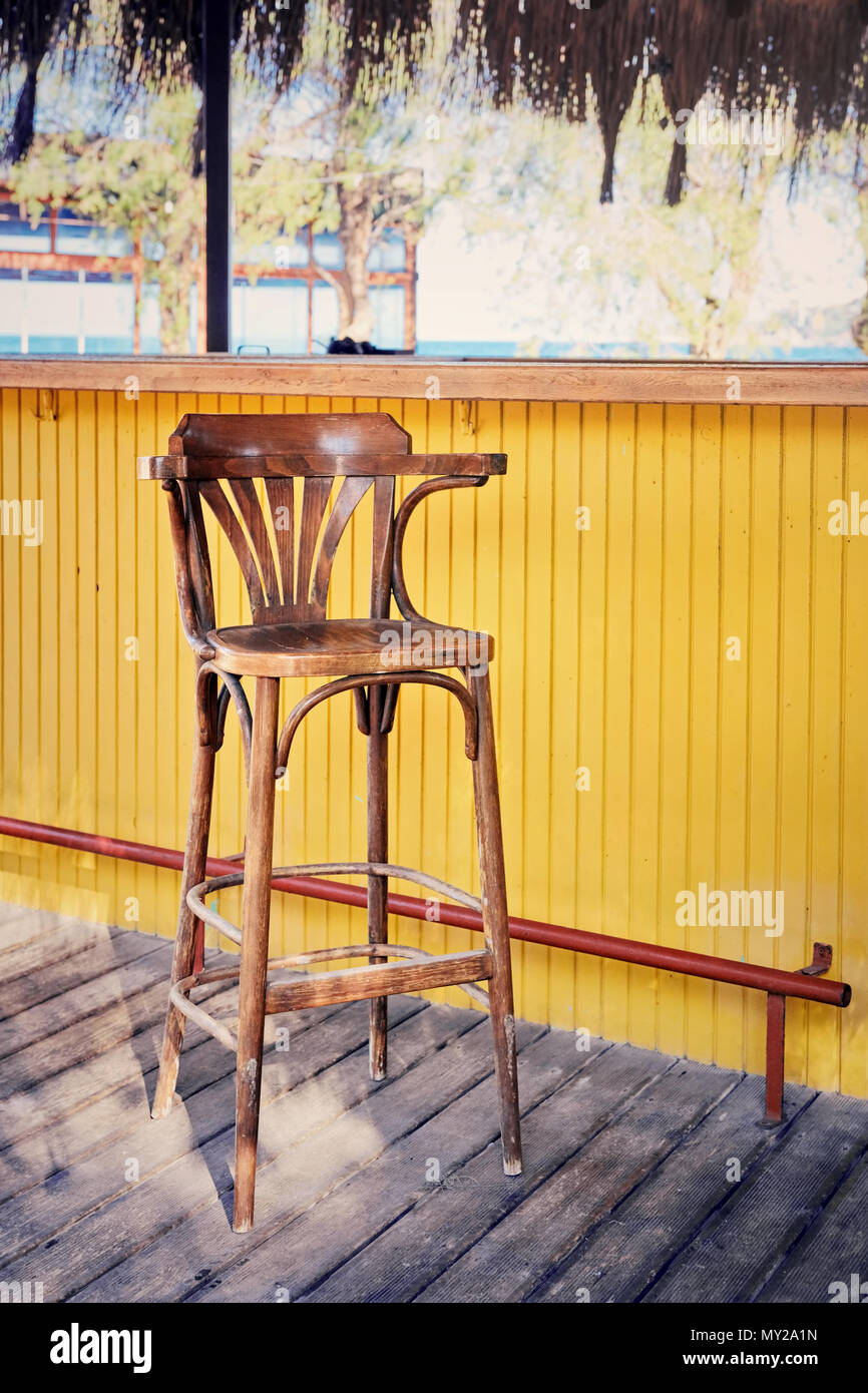 Yellow counter and vintage western style wooden bar stool on retro planks  in an outdoor holiday bar Stock Photo - Alamy