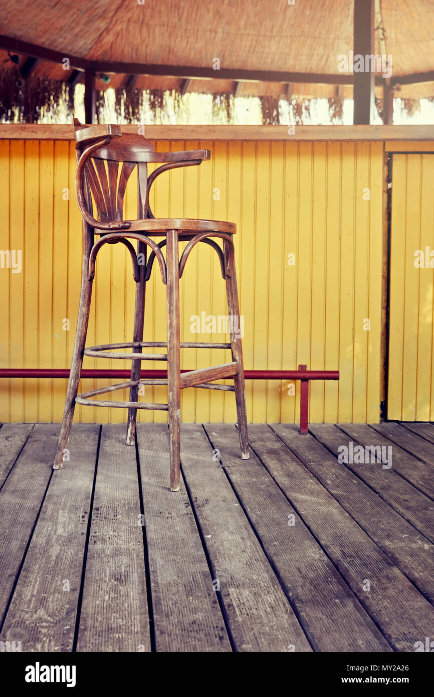 Vintage long wooden bar chair and yellow bar counter on retro wooden