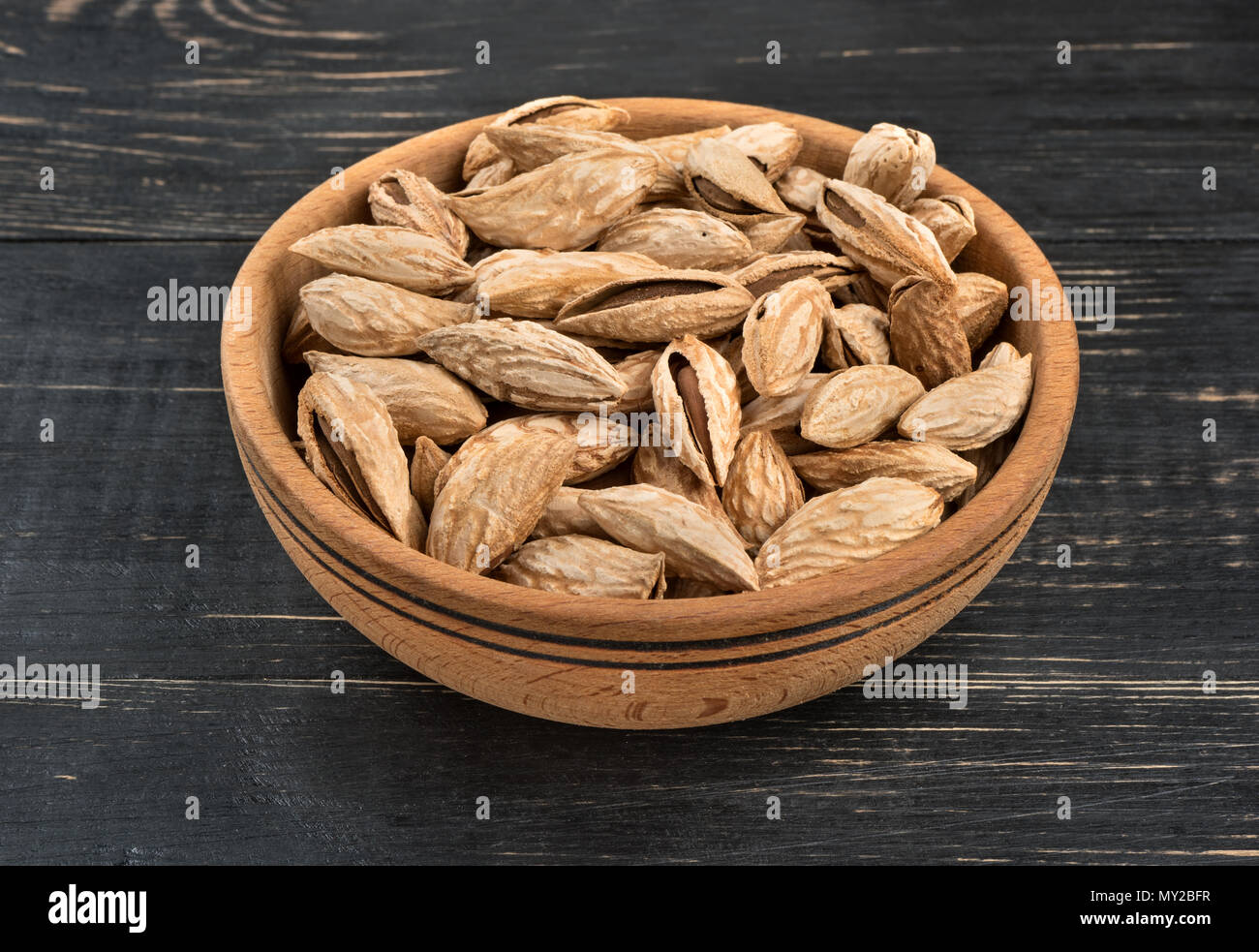 Uzbek inshell almonds in a bowl on wooden background Stock Photo - Alamy