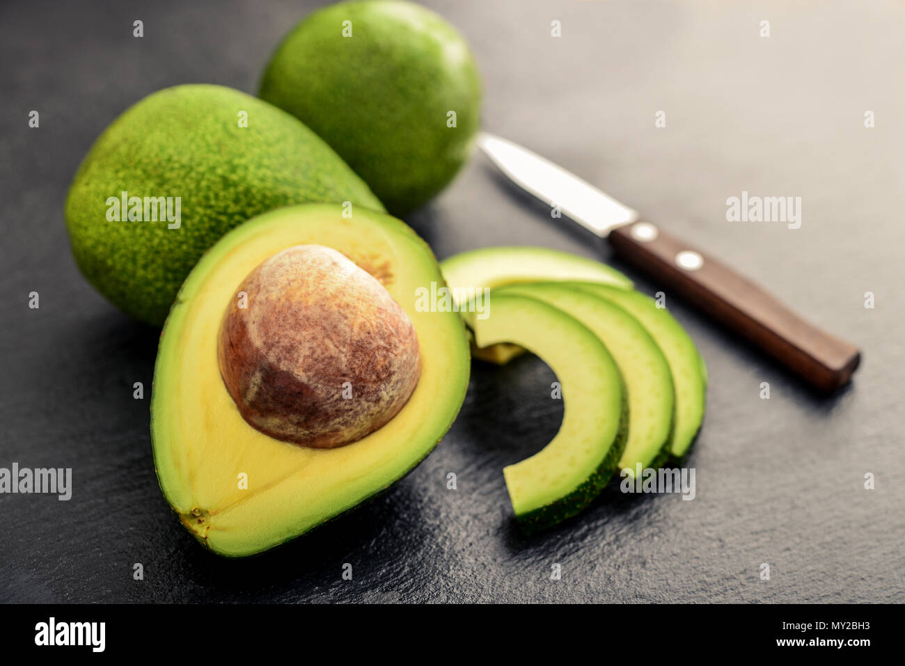 Fresh avocado over black slate background Stock Photo