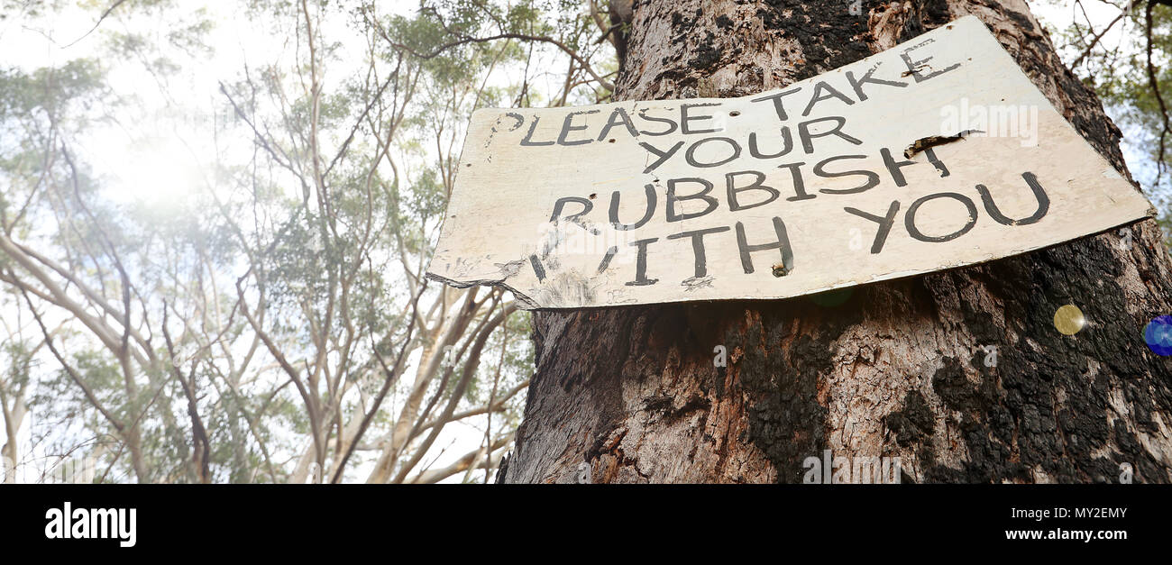 illegal dumping sign post instructing campers fishermen bush walkers hikers to take responsibility for removing all waste trash rubbish. Stock Photo