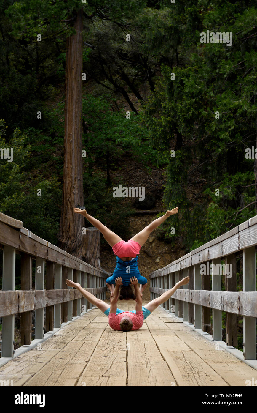 Acro Yoga practice by the rushing Yuba River in the California mountains, USA. Stock Photo