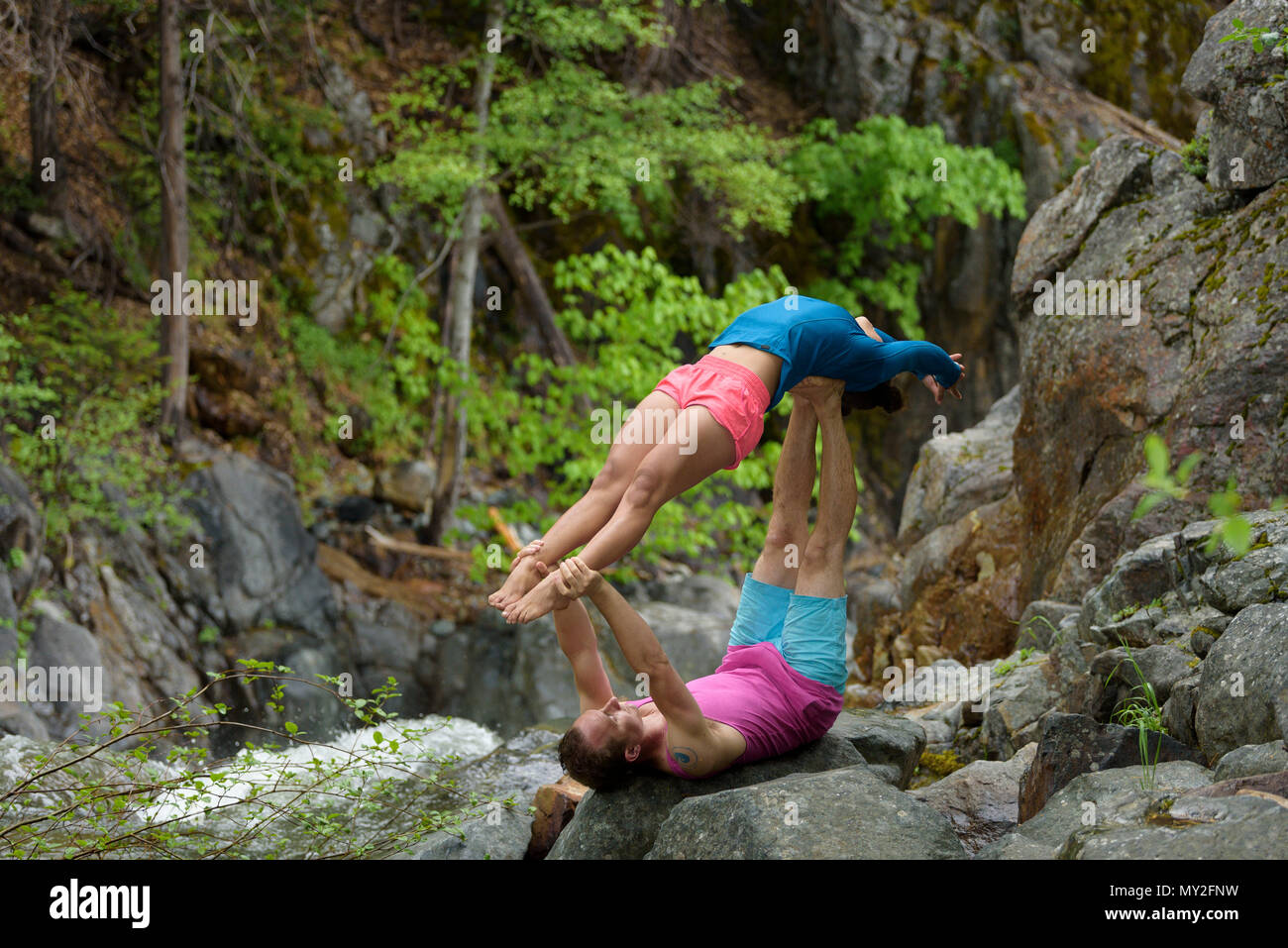 Acro Yoga practice by the rushing Yuba River in the California mountains, USA. Stock Photo