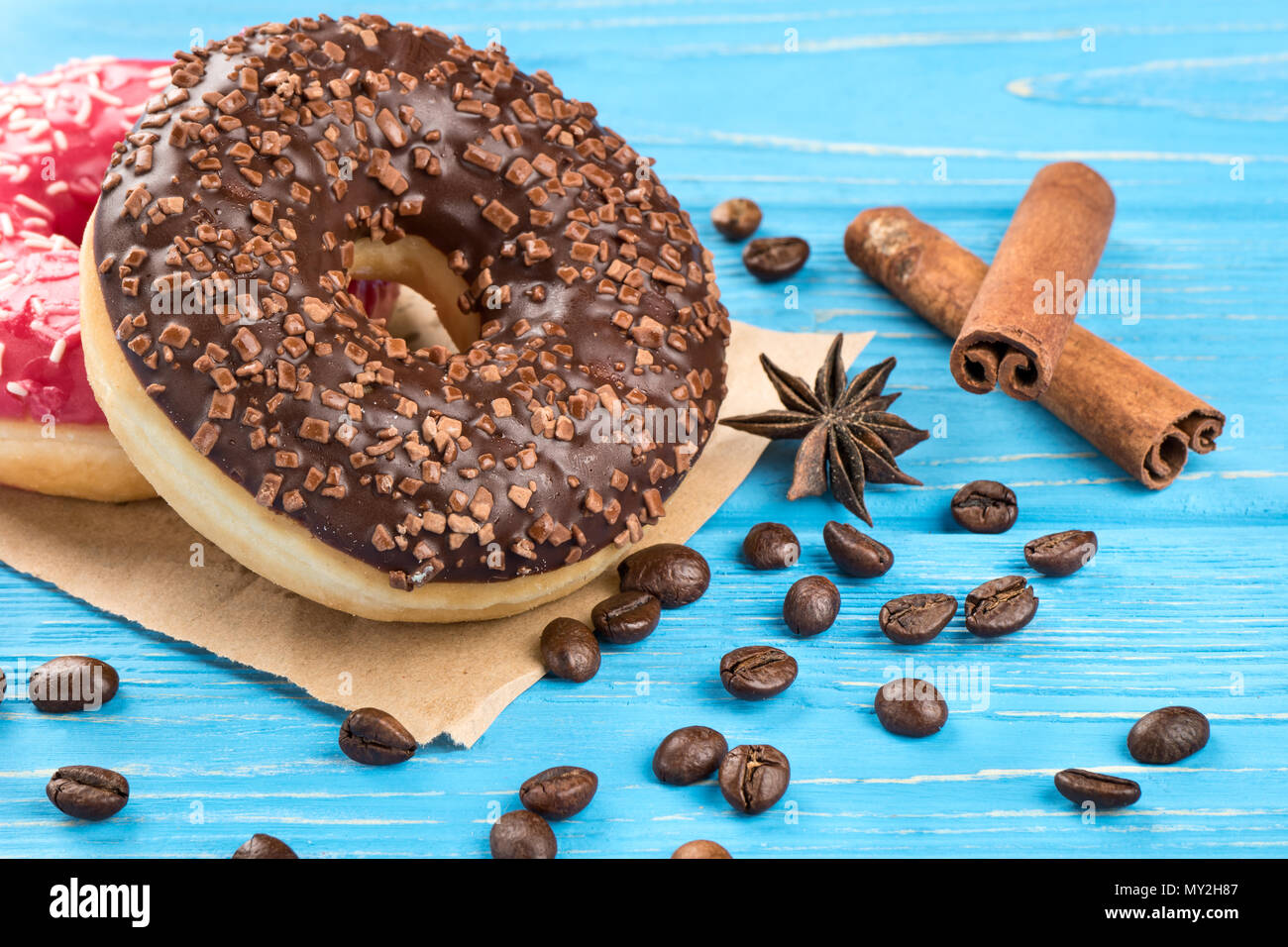 Chocolate donut with scattered grains of coffee close-up on the table Stock Photo