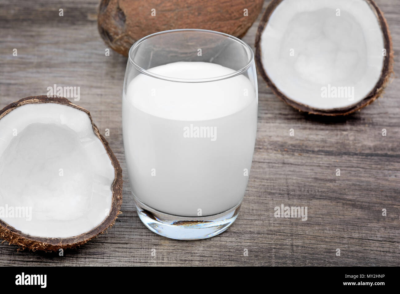 Close up of coconut milk in a glass on old wood table Stock Photo