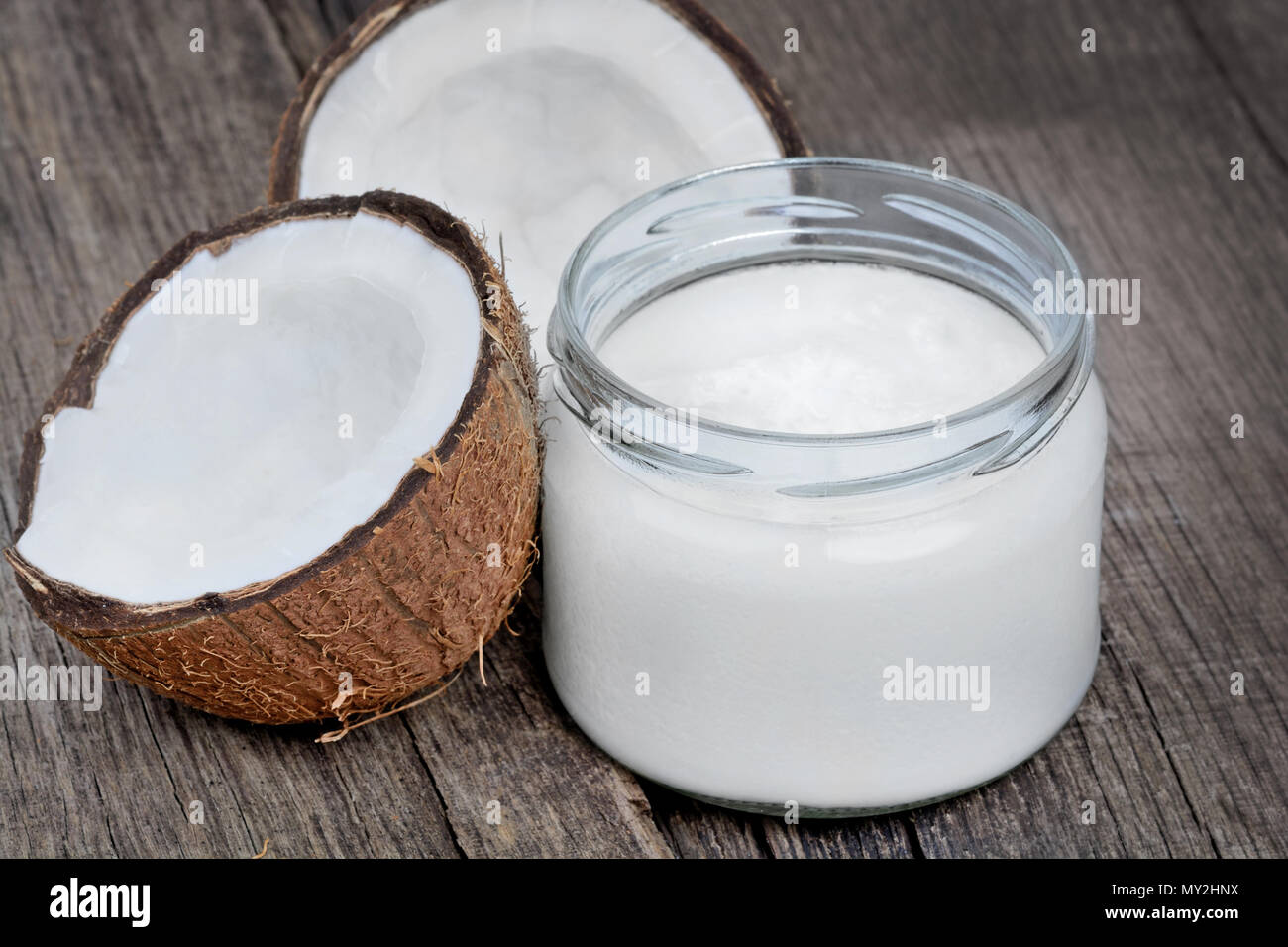 Close up of fresh coconut oil in glassware on old wood table Stock Photo