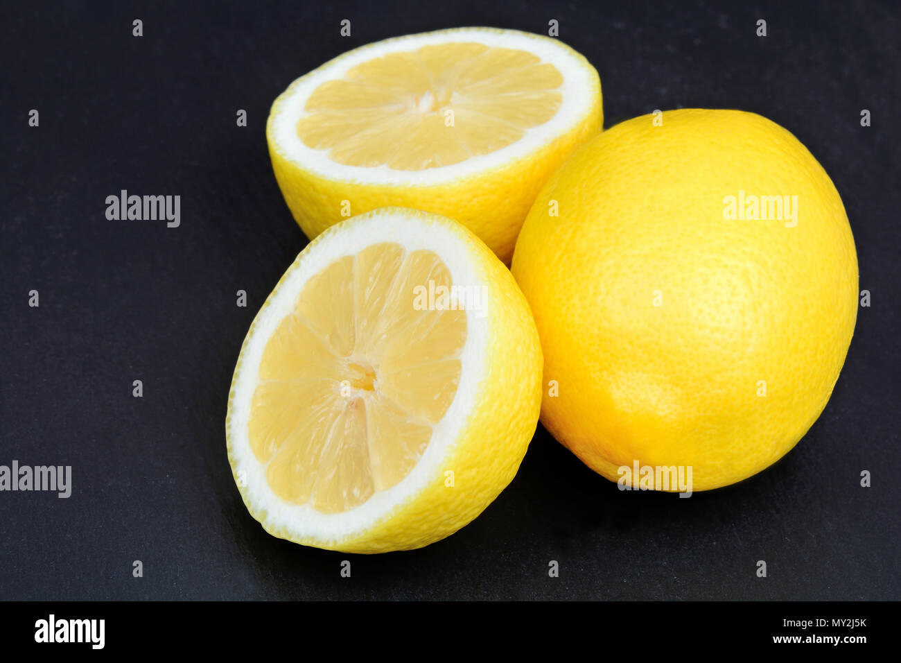 Fresh lemons on black slate Stock Photo
