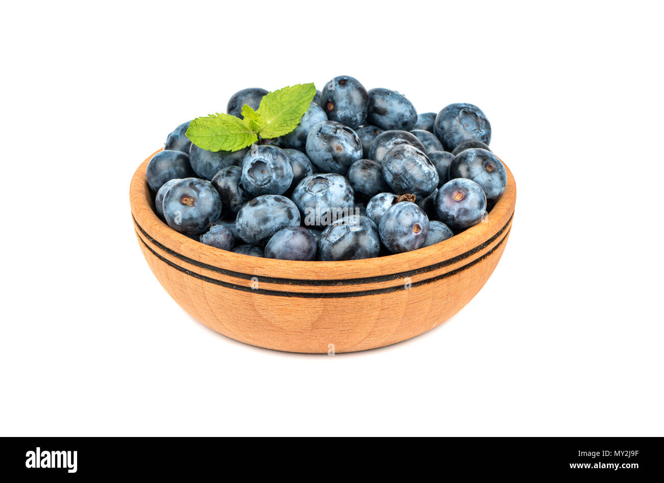 Wooden bowl with blueberries and mint leaves isolated on white background Stock Photo