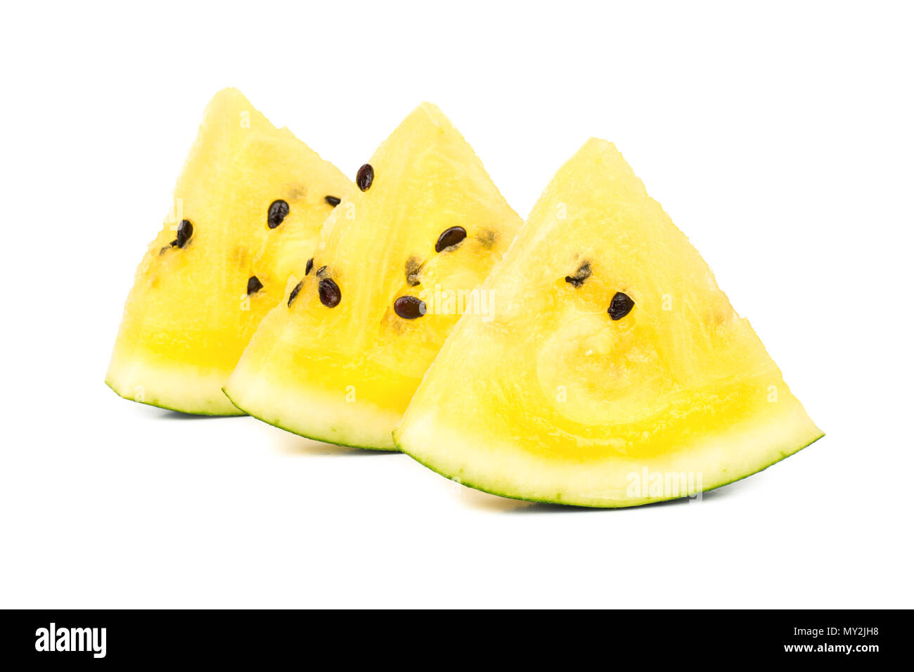 Three triangular slices of yellow watermelon on a white background ...