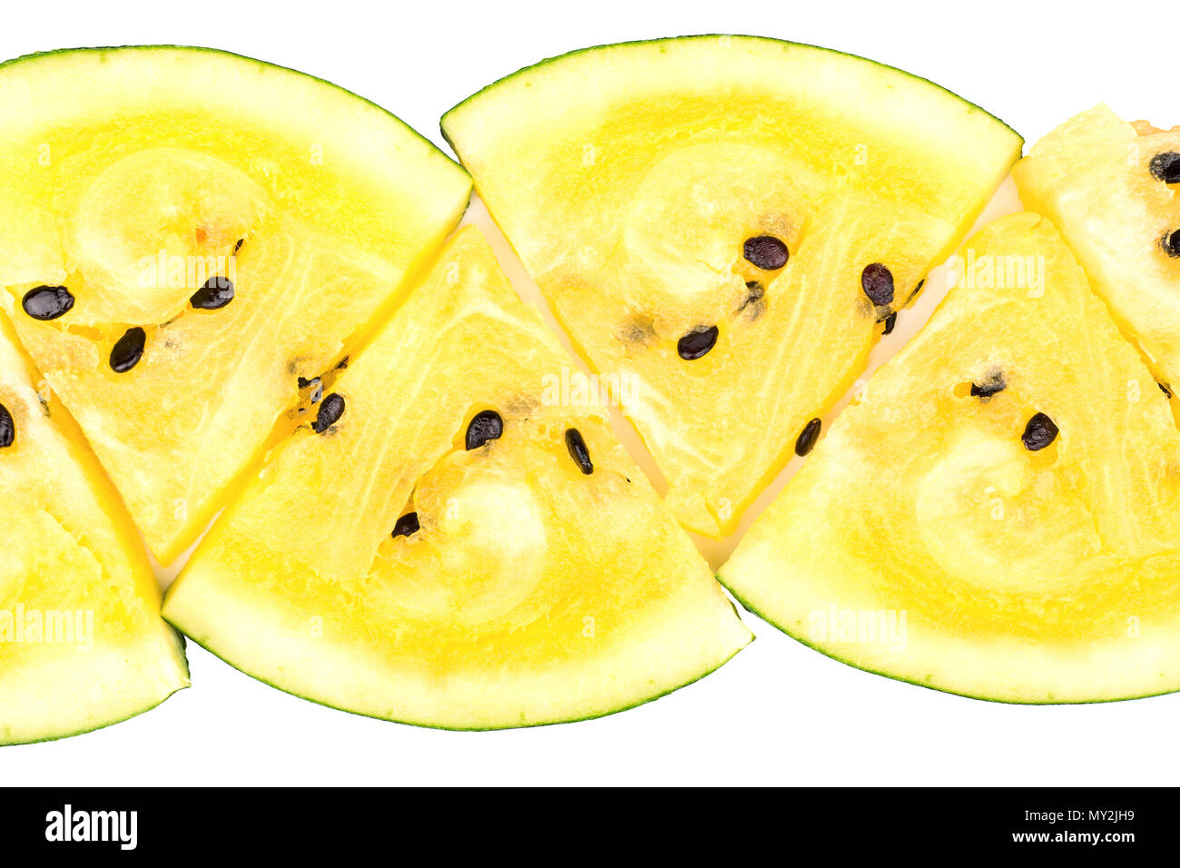 The triangular slices of yellow watermelon lined in a row on a white ...