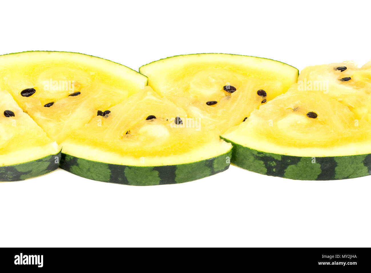 The triangular slices of yellow watermelon lined in a row on a white ...
