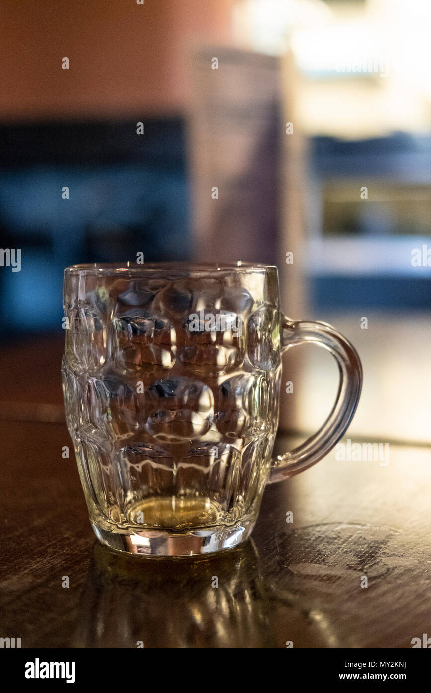 Empty beer in a dimpled glass often called a glass with a handle or dimple glass Stock Photo