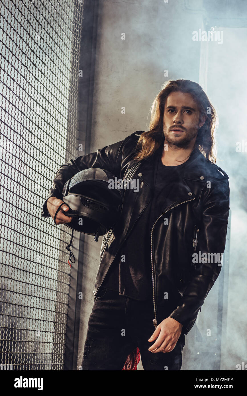 Stylish Long Haired Bearded Man In Leather Jacket Holding Helmet