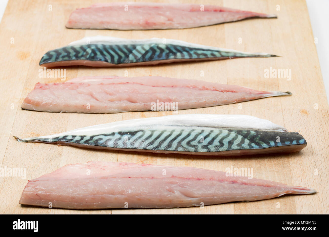 Raw mackerel fillets on a wooden chopping board from mackerel caught