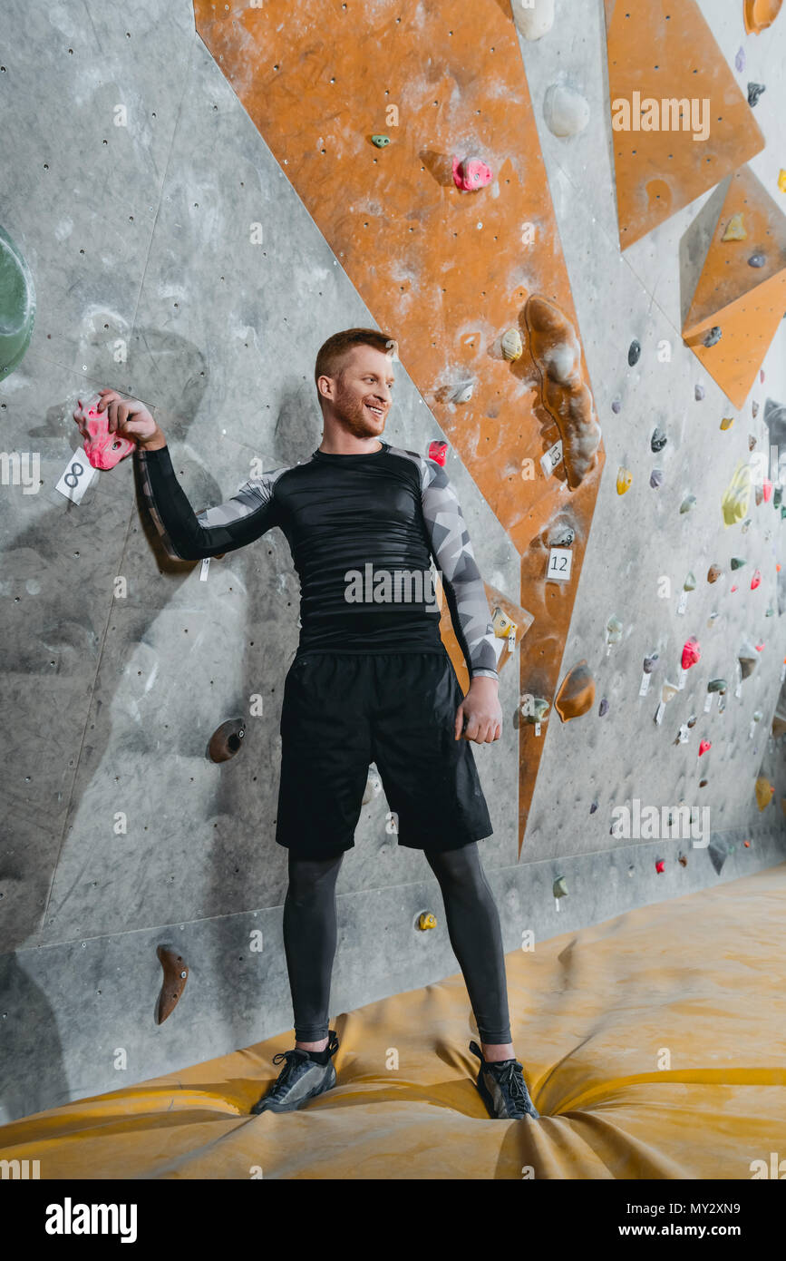Full-length shot of a young man in sportive attire standing near a climbing  wall and looking aside Stock Photo - Alamy