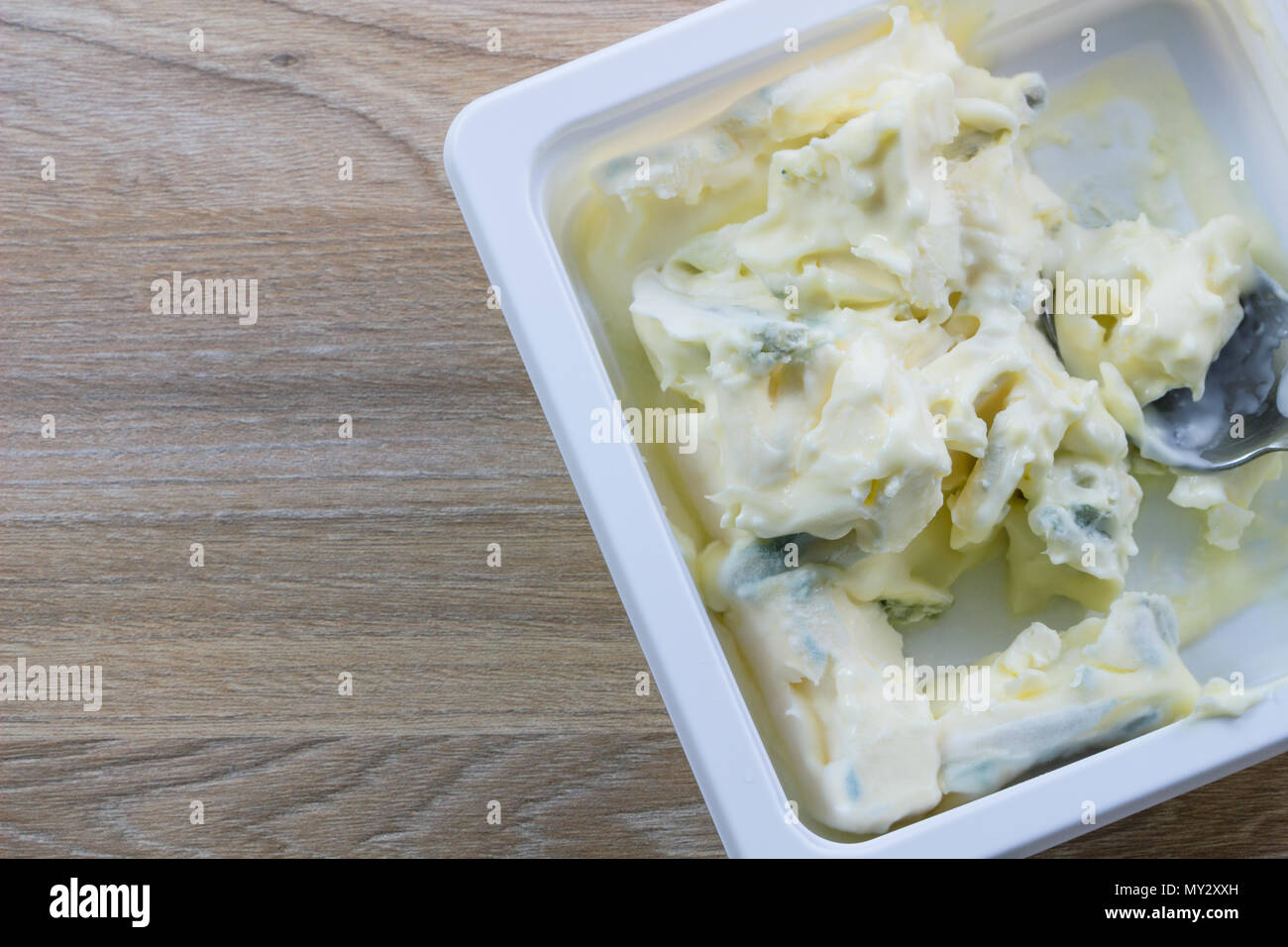 Mold, bacteria in a cream cheese on wood table background, Mold on