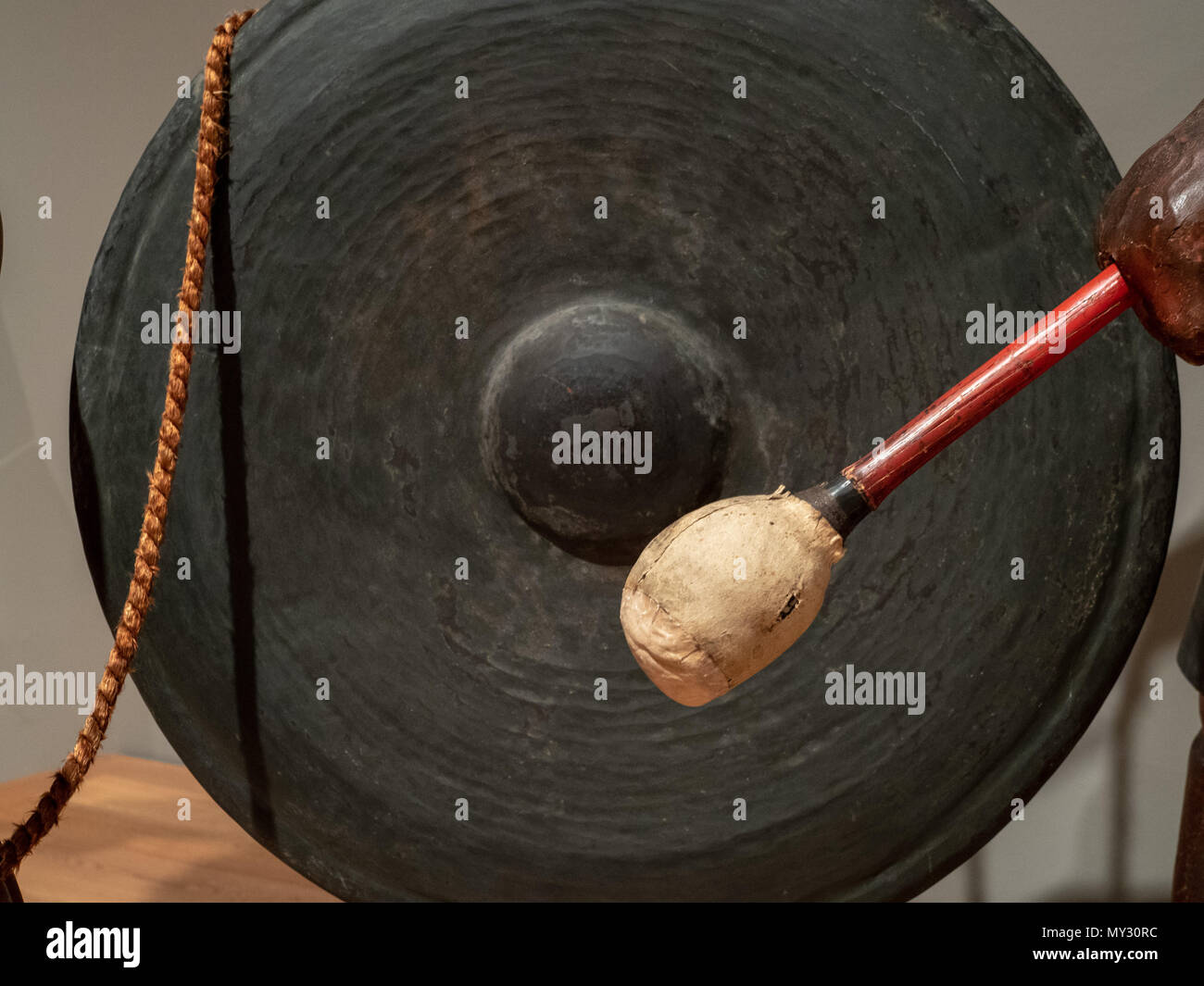 A mallet prepares to strike an ancient Asian gong Stock Photo Alamy