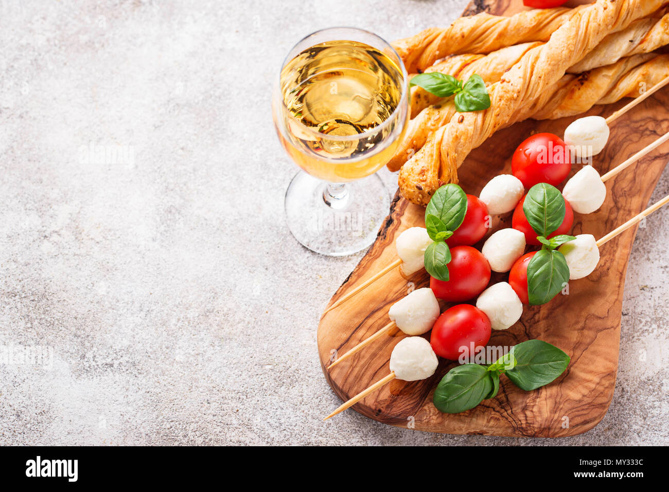 Traditional Italian antipasto caprese skewers and grissini bread Stock