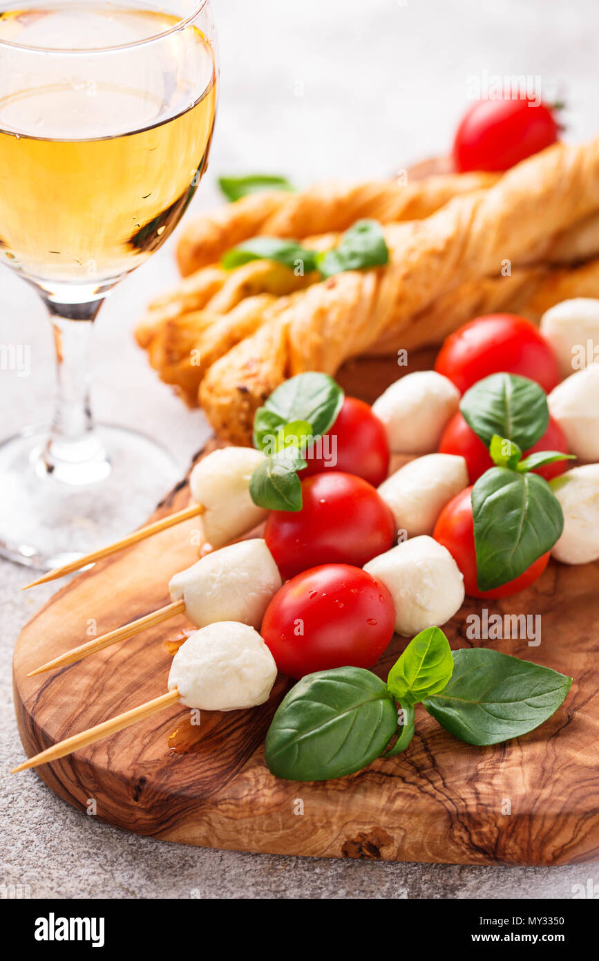 Traditional Italian antipasto caprese skewers and grissini bread Stock